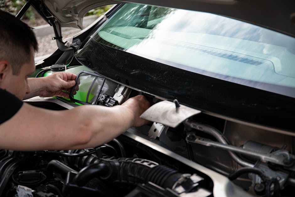 Technician applying resin for a windshield chip repair